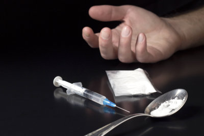 human hand with syringe and heroin